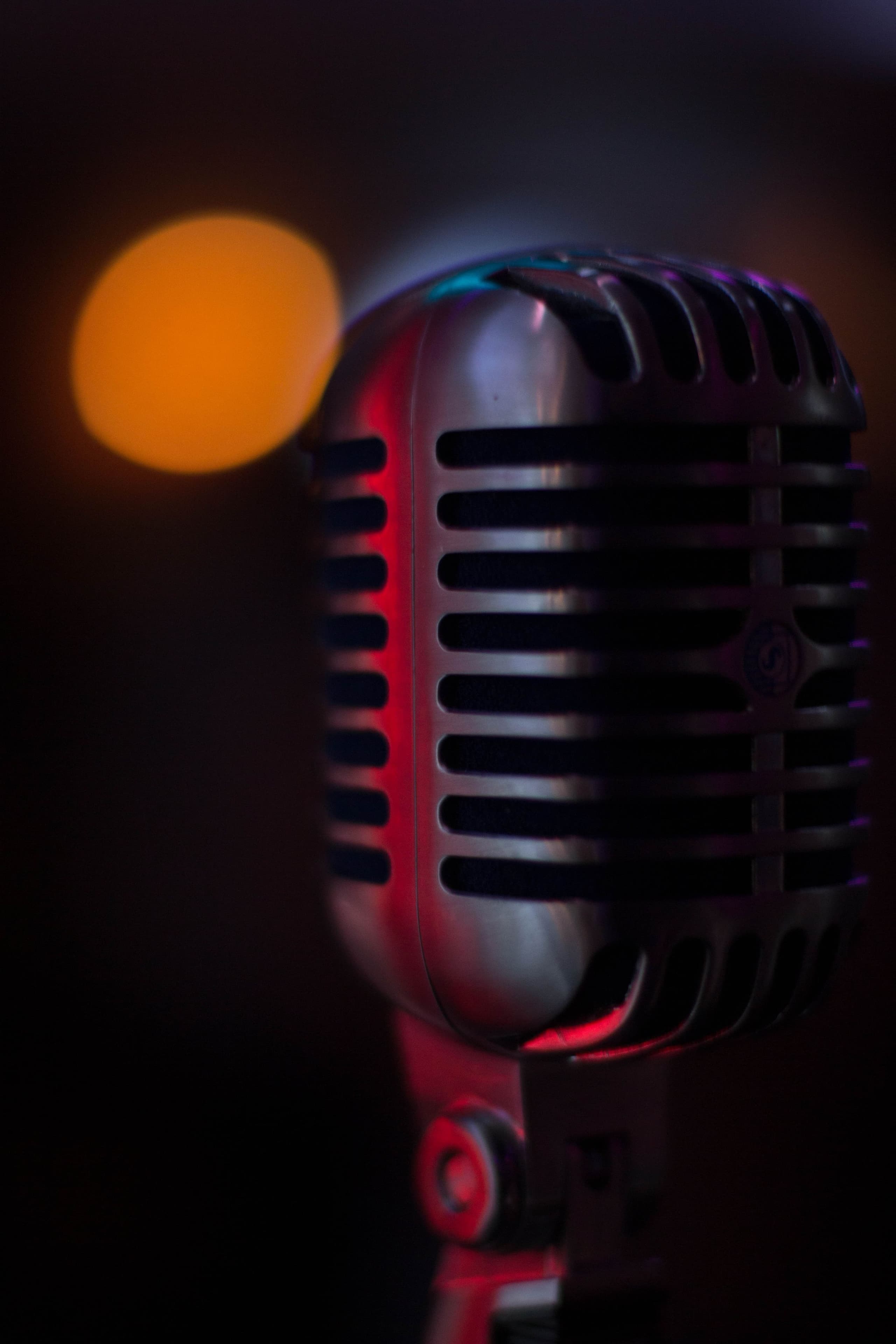 A vintage microphone glowing softly in the dark